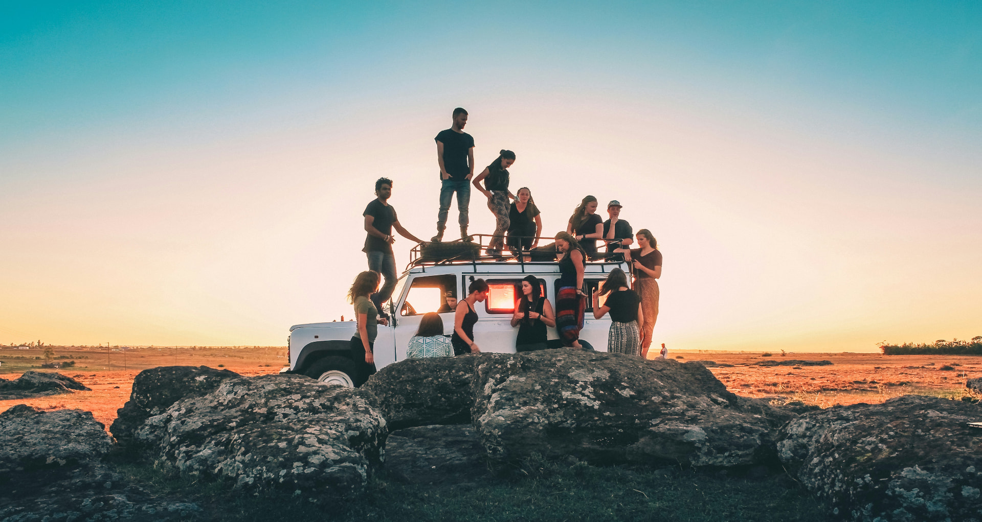 Friends silhouetted together against a setting sun