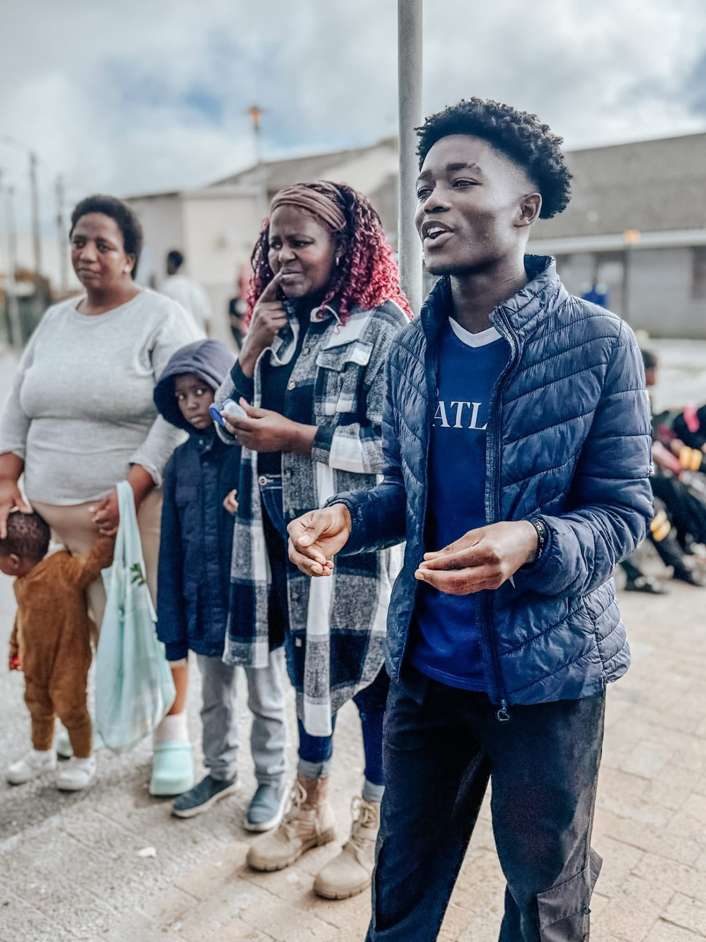 A young man sharing the gospel with families on a township street