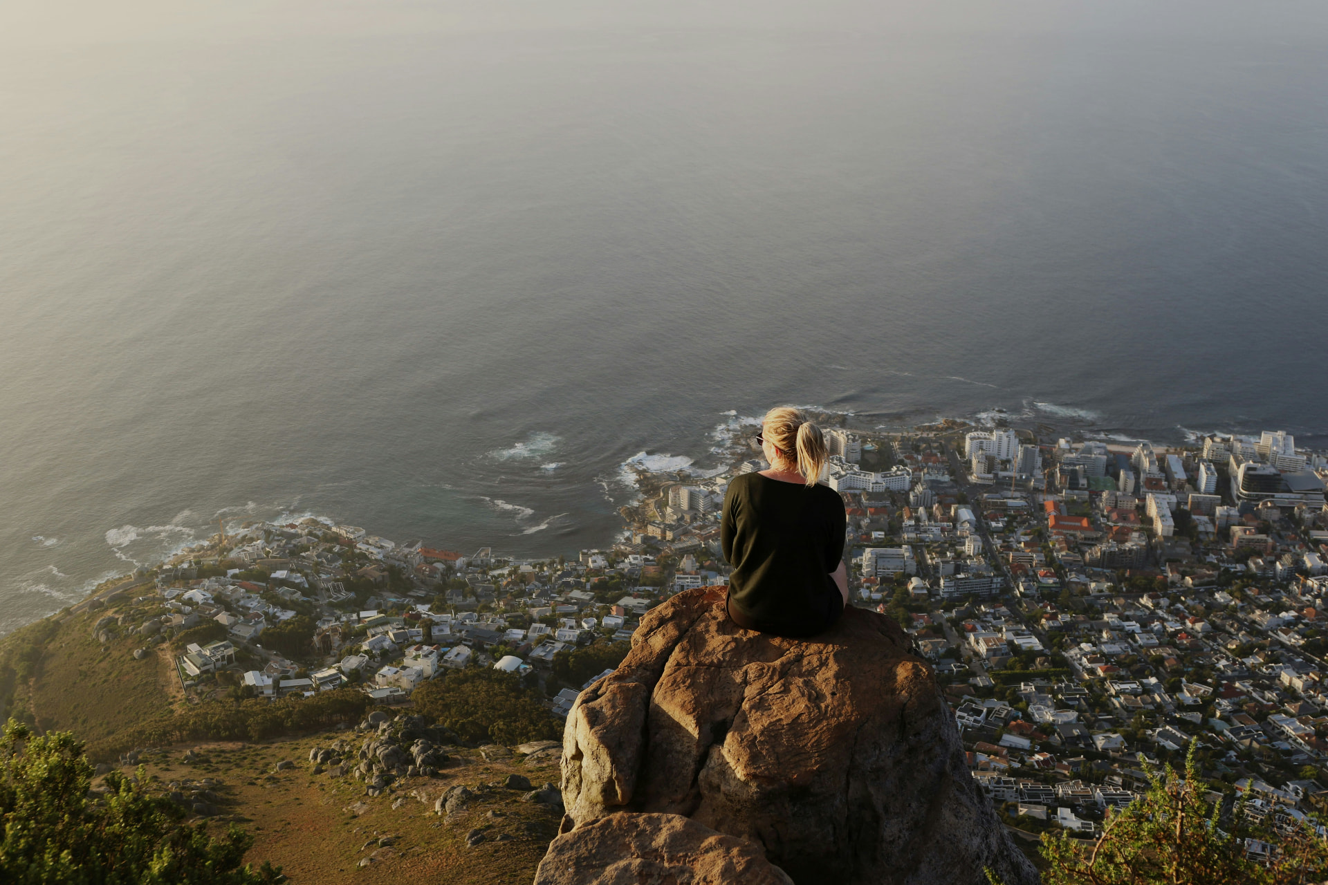 A person sitting on a rock above the Cape Town coastline